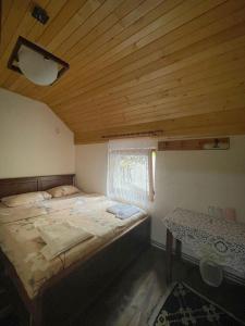 1 dormitorio con cama y techo de madera en Guest House Rilindja Valbone en Valbonë