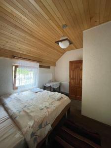a bedroom with a large bed with a wooden ceiling at Guest House Rilindja Valbone in Valbonë