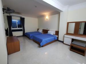 a hotel room with two beds and a television at Sóng Biển Hotel Cửa Lò in Cửa Lò