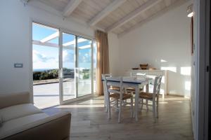 a dining room with a table and chairs and a window at Rena Majore Country Resort in Lampianu