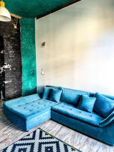 um sofá azul sentado numa sala de estar em cozy & charming apt. downtown em Timisoara