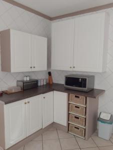 Pretoria的住宿－Zenith Guesthouse，厨房配有白色橱柜和台面上的微波炉