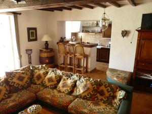 uma sala de estar com um sofá e uma cozinha em Maison Les Bardots em Savignac-de-Duras