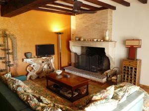 uma sala de estar com um sofá e uma lareira em Maison Les Bardots em Savignac-de-Duras