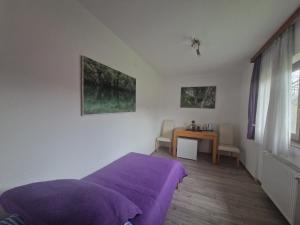 a bedroom with a purple bed and a table at Plitvice House Rosha in Plitvička Jezera