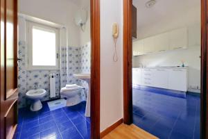 a blue and white bathroom with a toilet and a sink at Virgy Green House in Rome