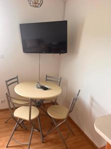 stół i krzesła z telewizorem na ścianie w obiekcie Przystań Znamirowice w mieście Znamirowice