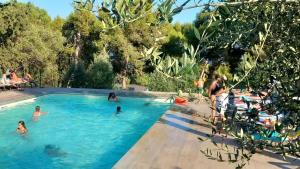 a group of people swimming in a swimming pool at Camping La Scogliera - Maeva Vacansoleil in Castro di Lecce