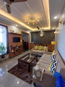 uma sala de estar com um sofá e uma mesa em Ganges Stay-Beautiful One BHK Apartment em Rishikesh