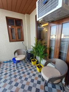 um quarto com duas cadeiras e uma mesa e plantas em Ganges Stay-Beautiful One BHK Apartment em Rishikesh