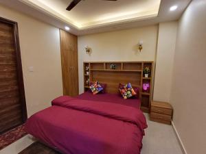 um quarto com uma cama grande e lençóis roxos em Ganges Stay-Beautiful One BHK Apartment em Rishikesh