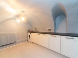 a kitchen with white cabinets and a black counter top at Pass the Keys Cosy 2 Bed Flat in London in a Historic Building in London