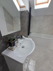 Homestay near motorway في Giarmata: حمام مع حوض استحمام ومغسلة بيضاء