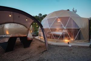une grande tente en forme de dôme avec une table en bois à l'intérieur dans l'établissement The X10 Glamping Pool Villa Khaoyai เขาใหญ่ - SHA Certified, à Pak Chong