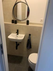 a bathroom with a sink and a mirror and a toilet at Apartment in zentraler Lage in Willich in Willich