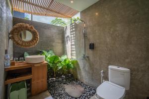 a bathroom with a shower and a toilet and a sink at Black Wood Cabin in Kintamani