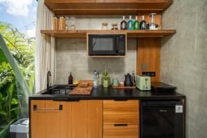 a kitchen with a stove and a microwave at Black Wood Cabin in Kintamani +26 photos