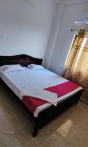 a bedroom with a bed with a red and white blanket at Glamour Palace in Bodh Gaya +4 photos