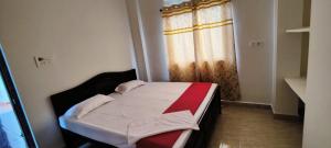 ein kleines Bett in einem Zimmer mit Fenster in der Unterkunft Glamour Palace in Bodh Gaya