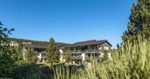 un edificio en medio de un campo de hierba alta en Résidence Pierre & Vacances Pyrenees 2000 Le Séquoia, en Bolquere Pyrenees 2000