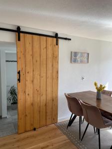 a wooden sliding door in a dining room with a table at Bohlinger Seeapartments in Bohlingen