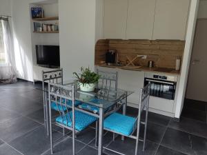 a kitchen with a glass table and two chairs at Chez Eve&Bruno 