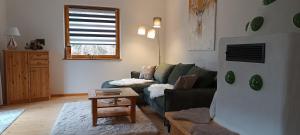 a living room with a green couch and a table at Bergkristall Ruhe und Aussicht auf 1100m in Sankt Lorenzen ob Murau