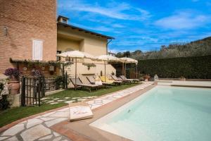 einen Pool im Garten mit Stühlen und Sonnenschirmen in der Unterkunft Villa Sassina in La Cava