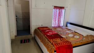 um pequeno quarto com uma cama e um chuveiro em KRIYA YOGA RETREAT CENTER GANGASAGAR em Dublāt