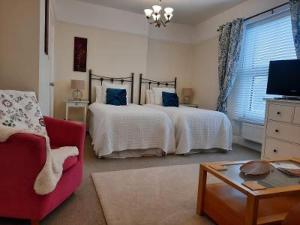 a bedroom with a bed with blue pillows on it at The Swallows B and B in Exmouth