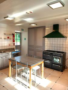 a kitchen with a wooden table and a stove at Château du Bourg in Saint-Denis-de-Gastines