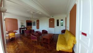 sala de estar con sofá amarillo y sillas en Château du Bourg en Saint-Denis-de-Gastines