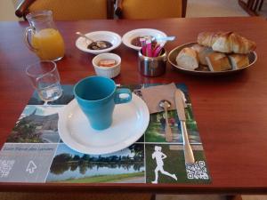 - une table avec une tasse de café et une assiette de pain dans l'établissement Château du Bourg, à Saint-Denis-de-Gastines