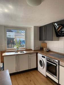 a kitchen with a sink and a washing machine at Bohlinger Seeapartments in Bohlingen