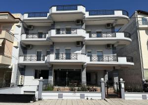 a white building with balconies on the side of it at Hotel Calisto in Leptokarya