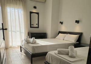 um quarto com 2 camas e um espelho em Hotel Calisto em Leptokarya