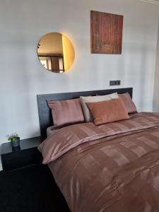 um quarto com uma cama grande e um espelho na parede em Panorama Suite Jelgava em Jelgava