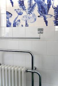 ein Badezimmer mit einem Heizkörper und blauen und weißen Fliesen in der Unterkunft Anna's House in Ickleford