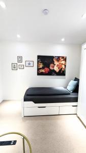 a white bedroom with a bed with a black mattress at Ferienwohnung an der Dhron in Neumagen-Dhron