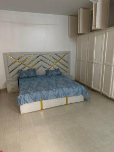 1 dormitorio con 1 cama con sábanas azules y almohadas azules en La belle étape, en Dakar