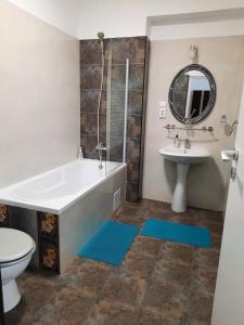 La salle de bains est pourvue d'une baignoire, d'un lavabo et de toilettes. dans l'établissement Cazare Apartament 2 camere, à Chiajna