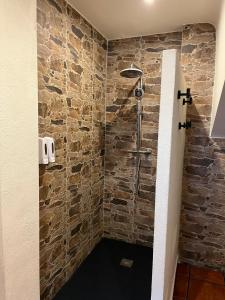 a bathroom with a shower with a stone wall at EL RIBAZO-Cuenca ciudad in Cuenca