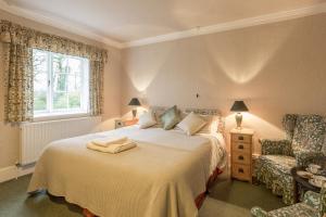 - une chambre avec un lit, une chaise et une fenêtre dans l'établissement Marshwood Farm B&B and Shepherds Hut, à Dinton