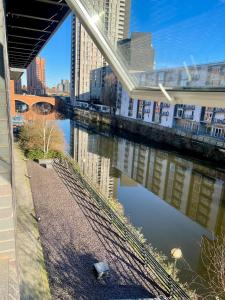 Blick auf einen Fluss mit Gebäuden und einer Brücke in der Unterkunft The Riverside in Manchester