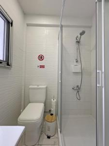 La salle de bains blanche est pourvue d'une douche et de toilettes. dans l'établissement Albert's Apartment Center 202B, à Larnaka