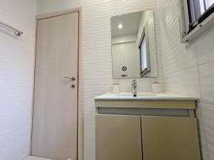 La salle de bains est pourvue d'un lavabo et d'un miroir. dans l'établissement Albert's Apartment Center 202B, à Larnaka