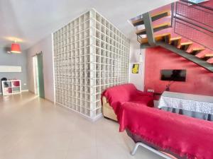 a living room with a red and white wall at La Casa de Enfrente in Antequera