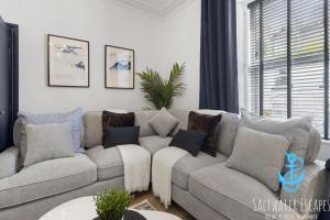 uma sala de estar com um sofá cinzento com almofadas em Harbour Townhouse em Brixham