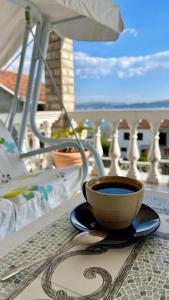 una taza de café en una mesa en un balcón en Family House with pool & sea view en Bijela