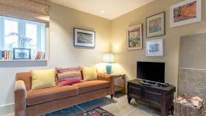 a living room with a couch and a television at Golconda Cottage in Brassington